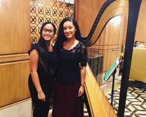 Settlement Music School harp student Kintan Silvany (left)