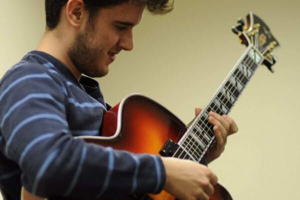 A guitar student rehearses at Settlement