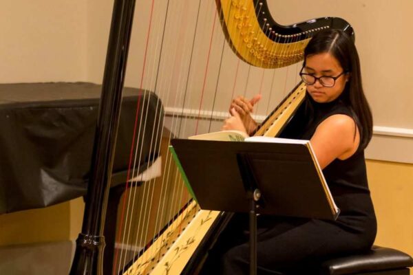 Settlement student plays the harp