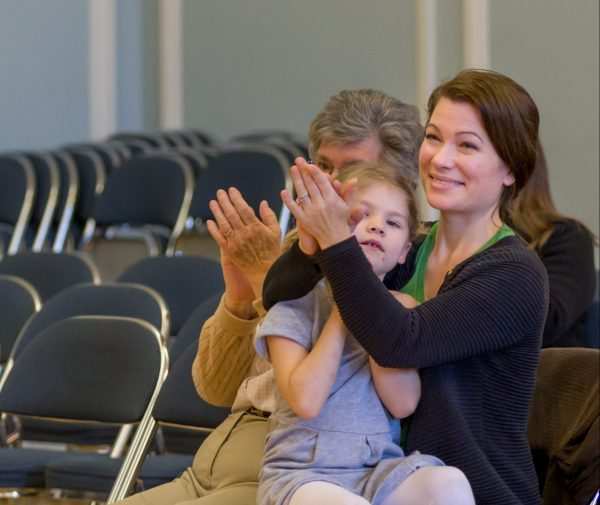 A parent applauds a young student at Settlement Music School.