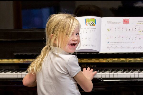A young student practices piano at Settlement Music School.