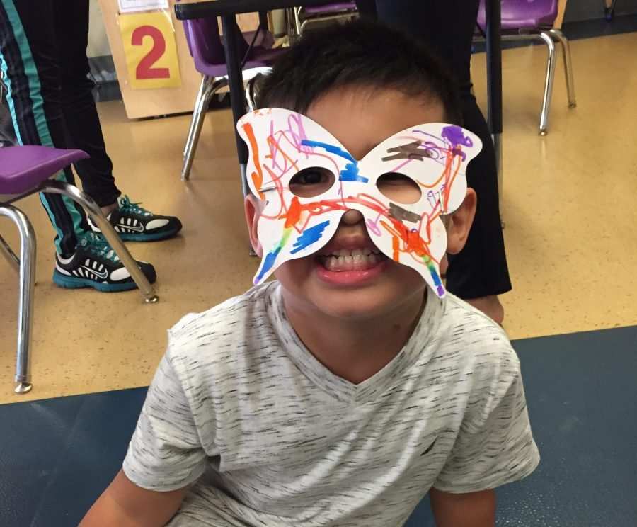 A Kaleidoscope student shows off his butterfly mask.