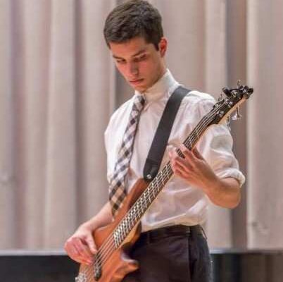 Settlement student plays the electric bass